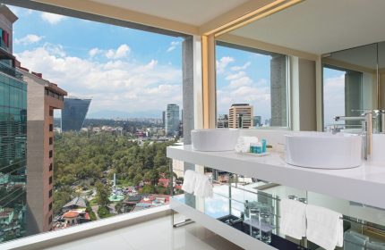 W Mexico City gay-friendly hotel bathroom with city view. Modern design, white sinks, towels. Upscale travel for gay men in Mexico City.