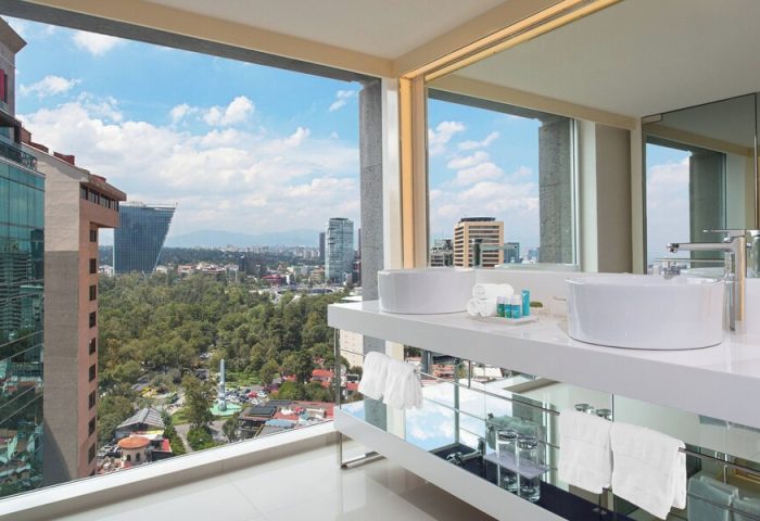 W Mexico City gay-friendly hotel bathroom with city view. Modern design, white sinks, towels. Upscale travel for gay men in Mexico City.