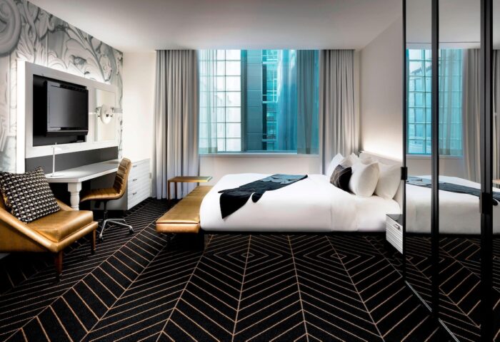 W Montréal gay-friendly hotel room. Modern design with bed, desk, chair, and geometric carpet. Great for gay men's travel in Montreal.
