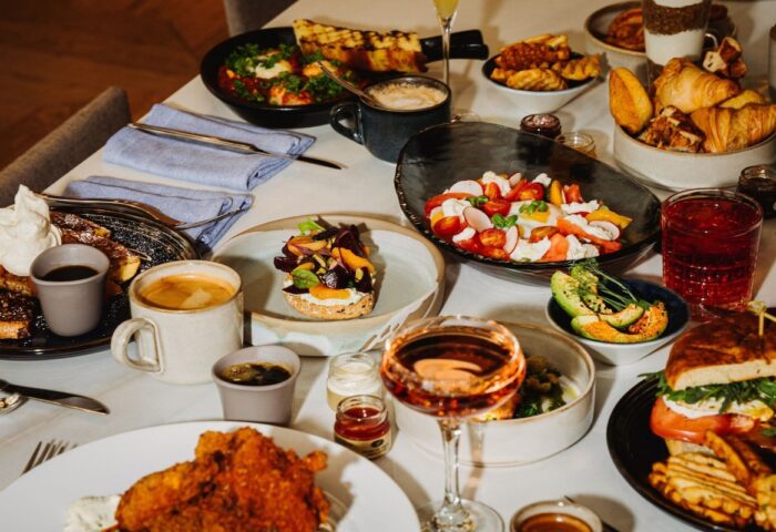 Gay-friendly W Montréal hotel brunch. Table with salad, toast, pastries, avocado, fried chicken, and drinks. Great food at W Montréal.