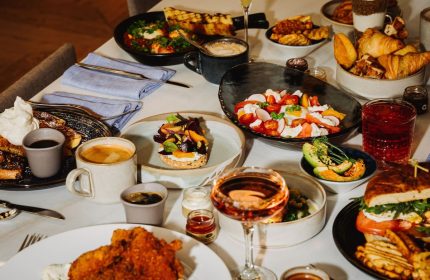 Gay-friendly W Montréal hotel brunch. Table with salad, toast, pastries, avocado, fried chicken, and drinks. Great food at W Montréal.