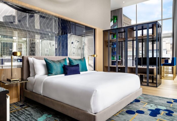 W Montréal gay-friendly hotel room. Modern design with a bed, pillows, closet, and city view. Ideal for gay travelers seeking style.