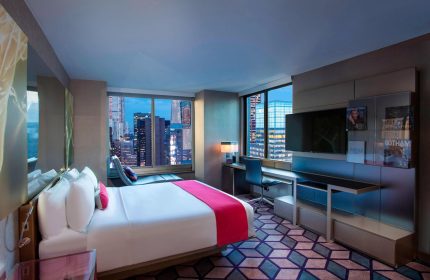 W New York Times Square hotel room at night. Gay-friendly hotel with city view. Modern interior design. Travel advice for gay men.