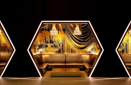 W New York Times Square gay-friendly hotel lounge. Hexagonal seating area with gold accents, modern lighting, and stylish design.