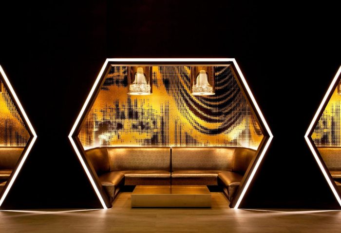 W New York Times Square gay-friendly hotel lounge. Hexagonal seating area with gold accents, modern lighting, and stylish design.