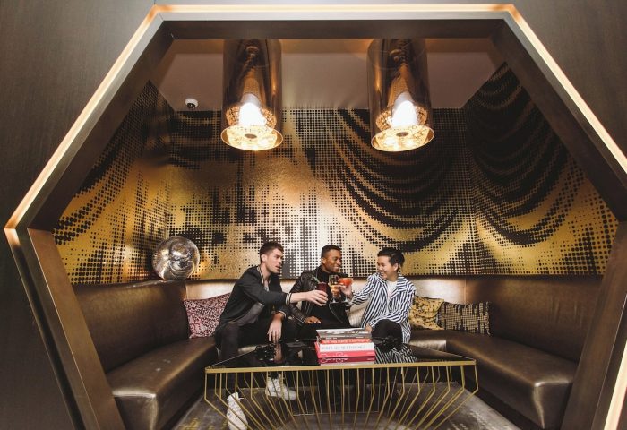 Gay-Friendly Hotel W New York Times Square: Three men toasting drinks in a stylish lounge with gold accents and modern design.