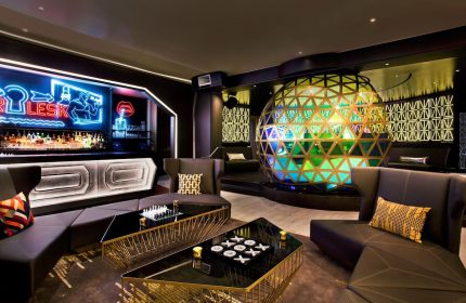 W New York Times Square gay-friendly hotel bar. Stylish lounge area with sofas, tables, and a large decorative sphere, perfect for socializing.