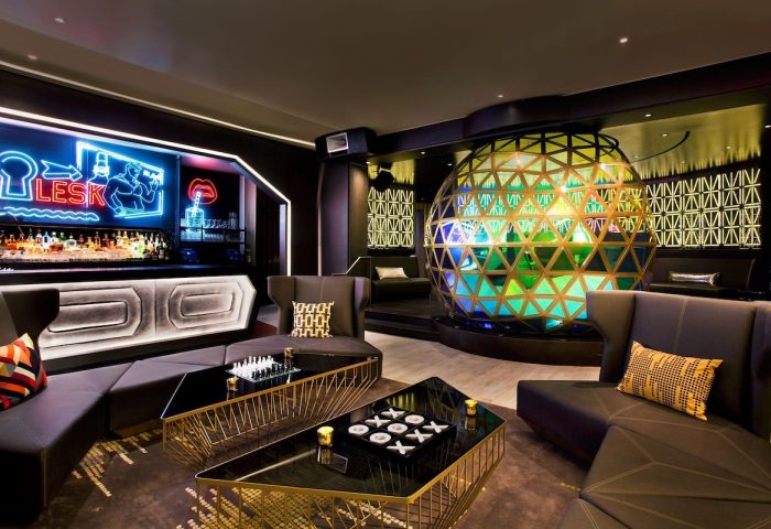 W New York Times Square gay-friendly hotel bar. Stylish lounge area with sofas, tables, and a large decorative sphere, perfect for socializing.