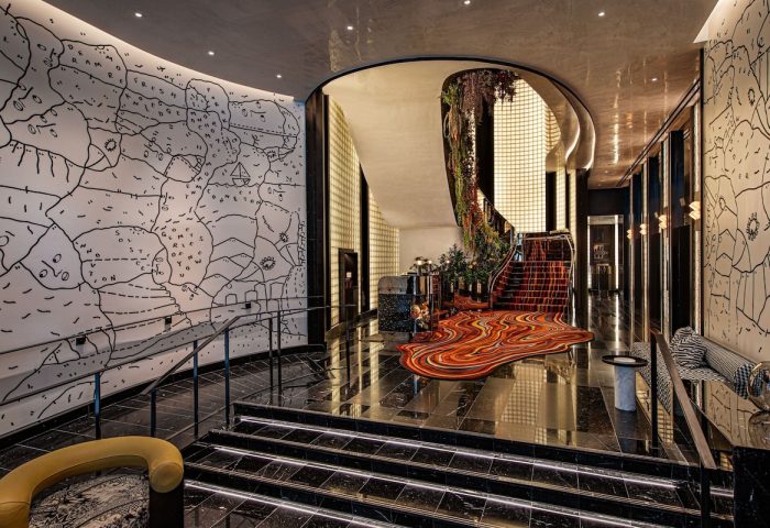 W New York - Union Square gay-friendly hotel lobby. Stylish design with unique wall art, staircase, and vibrant carpet. Upscale travel.