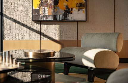 W New York - Union Square hotel interior. Modern chair, glass table, and art. Gay-friendly hotel design with textured wall and natural light.