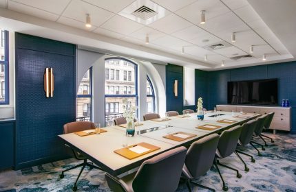W New York - Union Square gay-friendly hotel meeting room. Long table with chairs, large windows, and modern decor. Business travel.