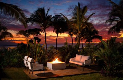 W Punta de Mita gay-friendly hotel outdoor seating area with fire pit at sunset. Palm trees and ocean view. Ideal for gay travel.