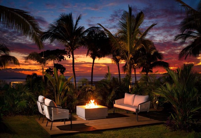 W Punta de Mita gay-friendly hotel outdoor seating area with fire pit at sunset. Palm trees and ocean view. Ideal for gay travel.
