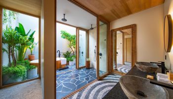W Punta de Mita's luxury bathroom. Stylish sinks, mirror, & an outdoor shower/tub area with lush greenery. Gay-friendly hotel design.