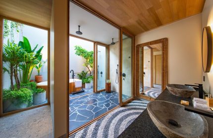 W Punta de Mita's luxury bathroom. Stylish sinks, mirror, & an outdoor shower/tub area with lush greenery. Gay-friendly hotel design.