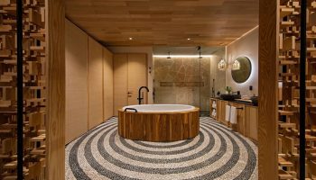 W Punta de Mita gay-friendly hotel bathroom. Round tub, stone floor, and wooden accents. Luxury travel for gay men. Hotel bathroom interior.