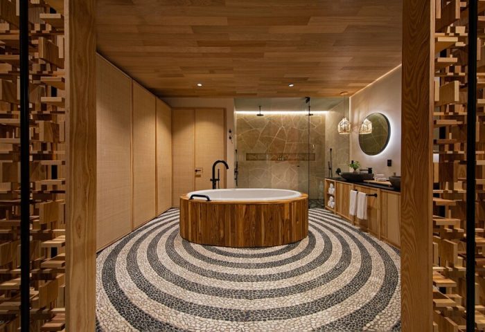 W Punta de Mita gay-friendly hotel bathroom. Round tub, stone floor, and wooden accents. Luxury travel for gay men. Hotel bathroom interior.