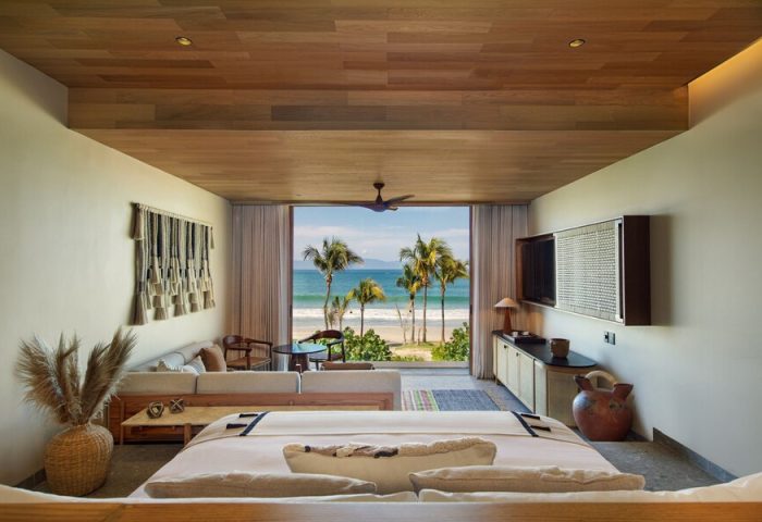 W Punta de Mita gay-friendly hotel room. Ocean view from bed, palm trees, beach. Luxury travel for gay men. Stylish decor, relaxing vibe.