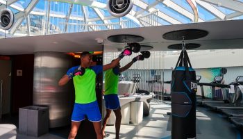 Gay-friendly Hotel W San Francisco gym: Man boxing with punching bag. Fitness center with treadmills, modern design, natural light.