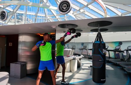 Gay-friendly Hotel W San Francisco gym: Man boxing with punching bag. Fitness center with treadmills, modern design, natural light.