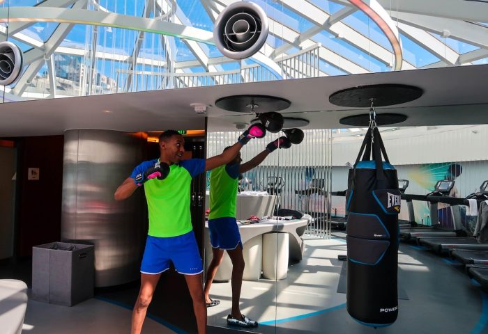 Gay-friendly Hotel W San Francisco gym: Man boxing with punching bag. Fitness center with treadmills, modern design, natural light.