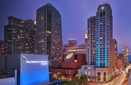 W San Francisco hotel at night. Gay-friendly hotel with city views. Blue Shield of California Theater in the foreground. Urban scene.