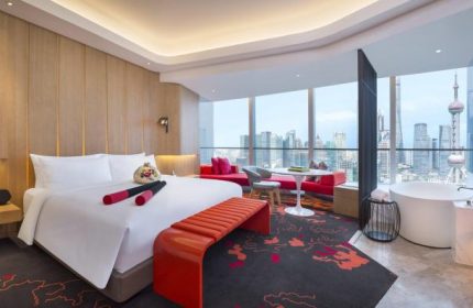 W Shanghai - The Bund hotel room with city view. Gay-friendly hotel with bed, sitting area, and bathtub. Modern design. Shanghai skyline.
