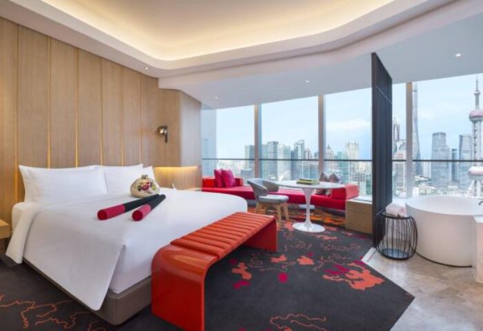 W Shanghai - The Bund hotel room with city view. Gay-friendly hotel with bed, sitting area, and bathtub. Modern design. Shanghai skyline.