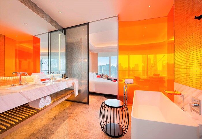 W Shanghai - The Bund hotel bathroom. Orange design, bathtub, and double sink. Gay-friendly hotel with modern design. Room with a view.