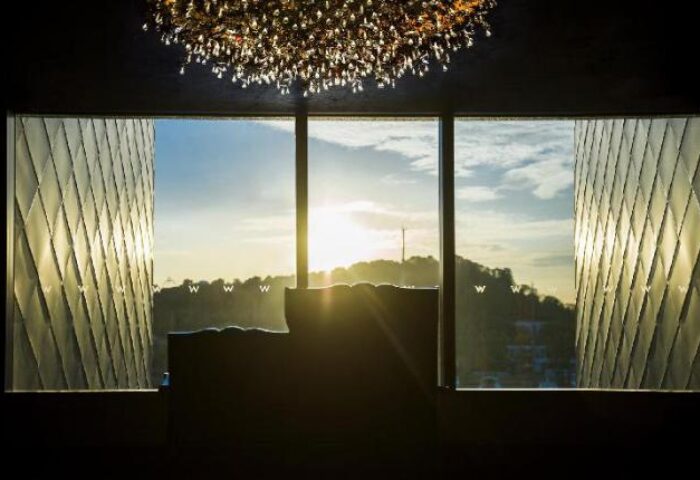 View from W Singapore - Sentosa Cove, a gay-friendly hotel. Sunrise over Sentosa Island. Luxury hotel interior with a chandelier. SG Clean Certified.