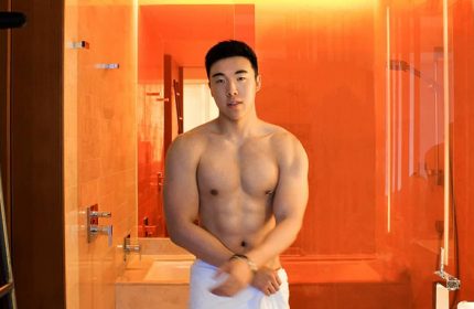 Gay-friendly W Taipei hotel: Asian man with muscular body in bathroom with orange decor. Gay travel advice, Taiwan hotel.