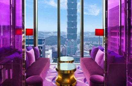 W Taipei gay-friendly hotel room with purple decor, sofas, and Taipei 101 view. Luxury travel for gay men in Taiwan.