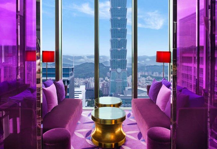 W Taipei gay-friendly hotel room with purple decor, sofas, and Taipei 101 view. Luxury travel for gay men in Taiwan.