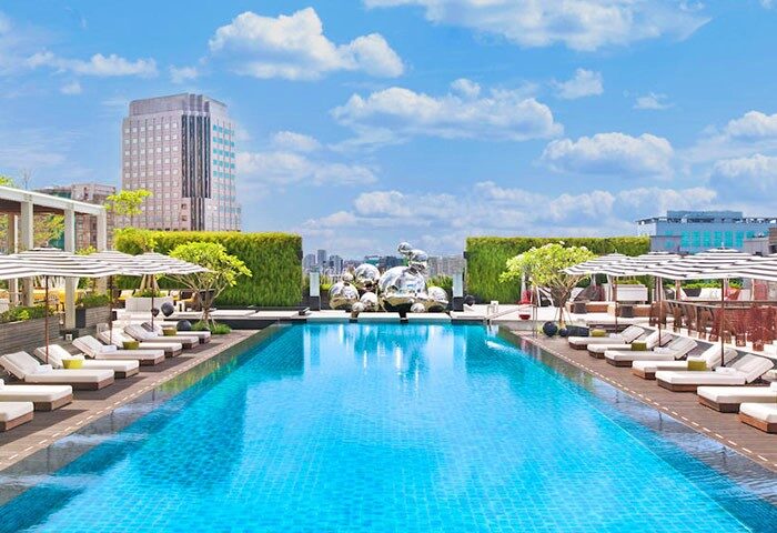 W Taipei gay-friendly hotel pool. Rooftop pool with city views, lounge chairs, and umbrellas. Modern design and luxurious amenities. Perfect for gay travelers.