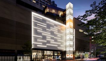 W Toronto, a gay-friendly hotel. The exterior features modern architecture with illuminated panels and a glass tower. Street view at night.