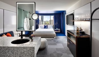 W Toronto hotel room. Modern design, blue accents, king bed, city view. Gay-friendly hotel with stylish interiors for a comfortable stay.