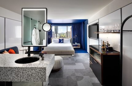 W Toronto hotel room. Modern design, blue accents, king bed, city view. Gay-friendly hotel with stylish interiors for a comfortable stay.