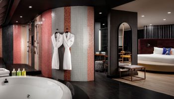W Toronto hotel suite. Bathtub, mosaic tile shower, robes, and bedroom view. Gay-friendly travel at W Toronto for gay men.