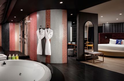 W Toronto hotel suite. Bathtub, mosaic tile shower, robes, and bedroom view. Gay-friendly travel at W Toronto for gay men.