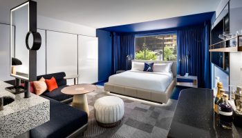 W Toronto hotel room interior. Modern design, blue accents, king bed, seating area. Gay-friendly hotel for gay travelers.