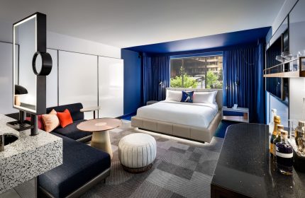 W Toronto hotel room interior. Modern design, blue accents, king bed, seating area. Gay-friendly hotel for gay travelers.