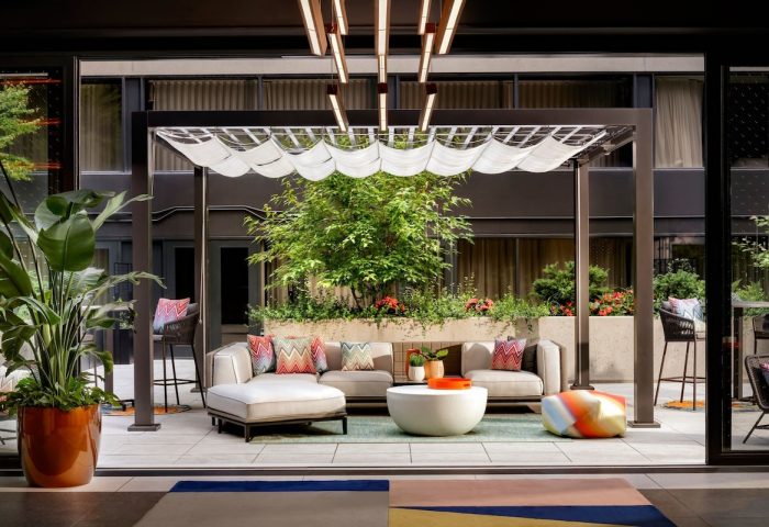 W Toronto gay-friendly hotel patio. Outdoor seating area with pergola, plants, and modern furniture. Stylish Toronto travel destination.