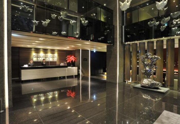 WESTGATE Hotel lobby. Gay-friendly hotel's modern interior design, reception desk, art sculptures, and reflective black marble flooring.