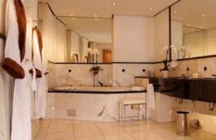 Bathroom at Wasserturm Hotel Cologne, a gay-friendly Curio Collection by Hilton. Features a bathtub, robes, and modern design.