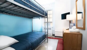 West Side YMCA Hostel gay-friendly hotel room with bunk beds, desk, and TV. A budget-friendly option for gay travelers in NYC.