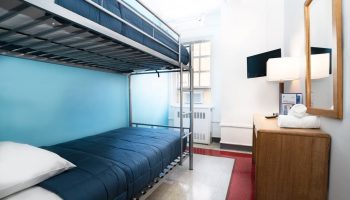 West Side YMCA Hostel gay-friendly hotel room with bunk beds, desk, and TV. A budget-friendly option for gay travelers in NYC.