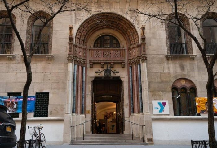 West Side YMCA Hostel, a gay-friendly hotel. Building's entrance with arched doorway, steps, & YMCA logo. Great for gay travel.