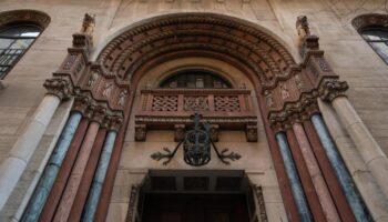 Ornate entrance to West Side YMCA Hostel, a gay-friendly hotel. Architectural details include carved stone, columns, and an arched doorway.