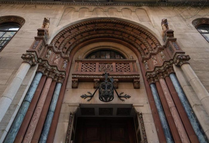 Ornate entrance to West Side YMCA Hostel, a gay-friendly hotel. Architectural details include carved stone, columns, and an arched doorway.