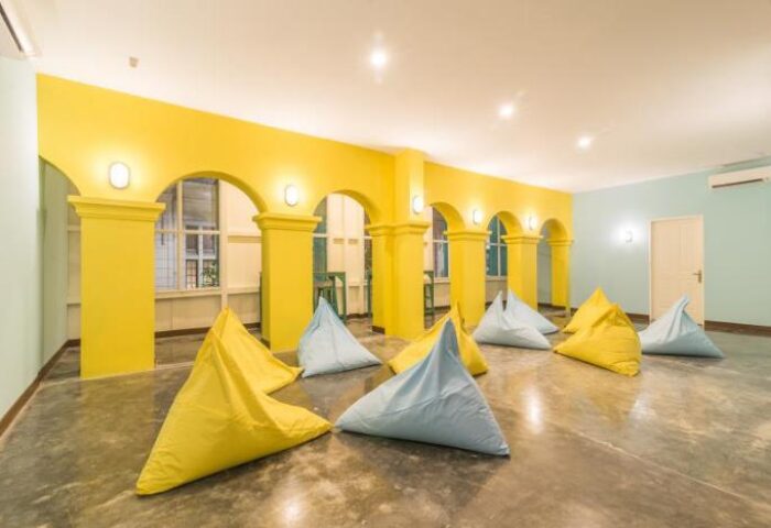 Wonderloft Hostel's gay-friendly lounge area. Yellow arches, blue and yellow beanbags. A welcoming space for gay travelers.
